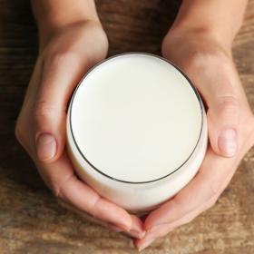 Hands cupping glass of milk