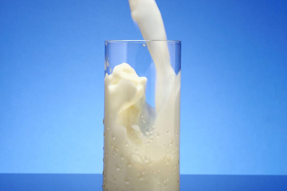 Milk being poured into a tall glass