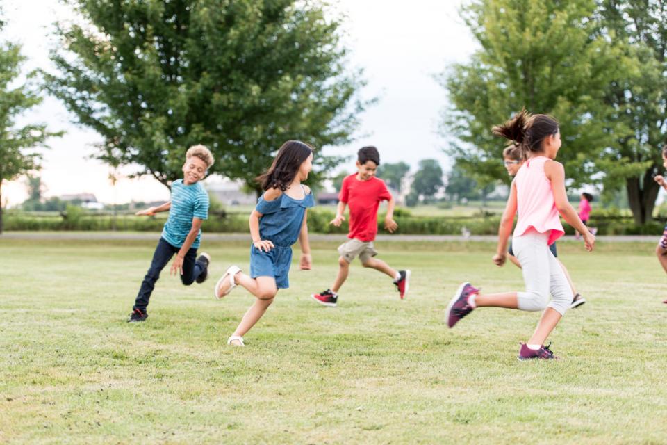 Kids playing soccer in a field