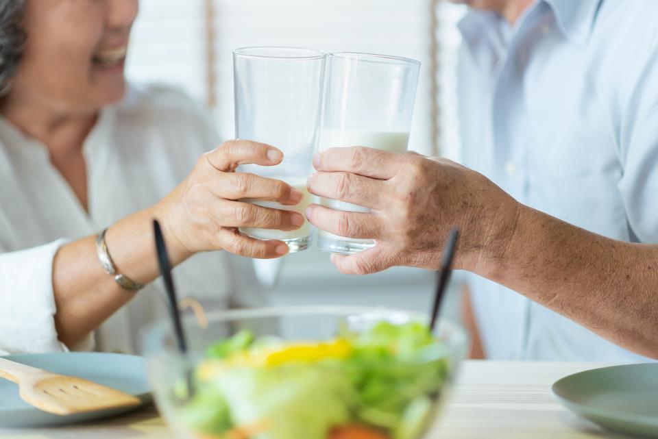 2 people holding a glass of milk each