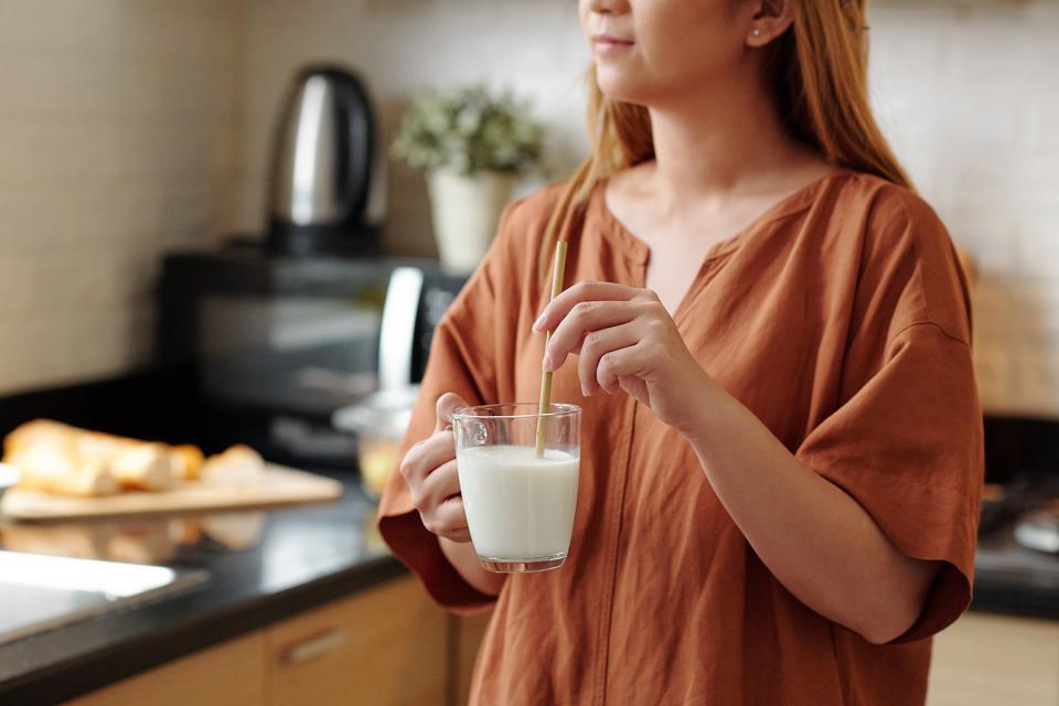 young woman drinking milk with a bamboo straw