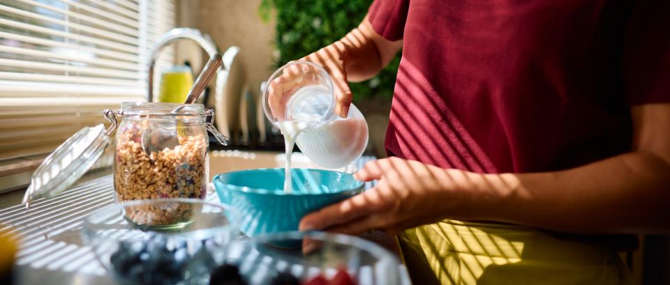 womam pouring milk in a bowl