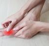 Woman rubbing her toe with red highlight of inflammed area
